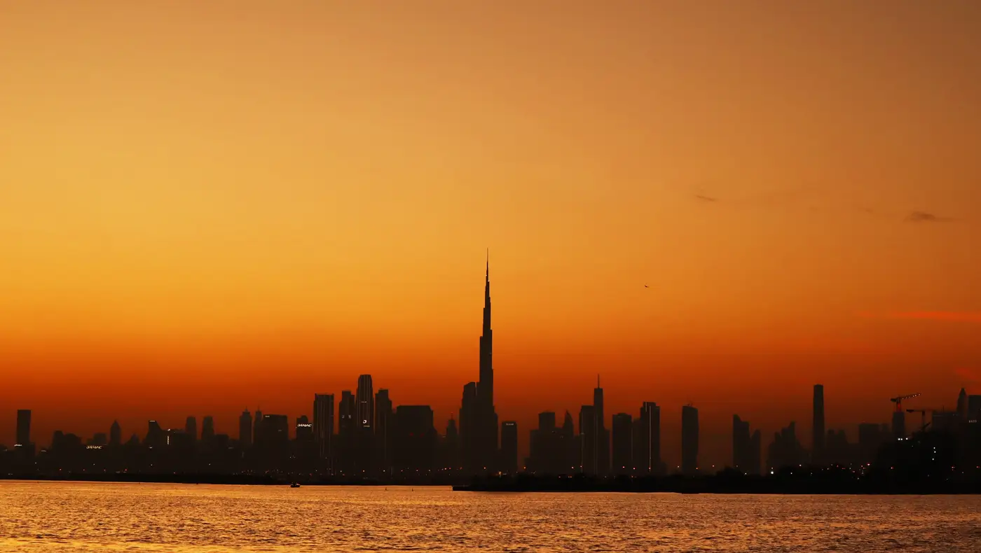 Deep orange sunset over Burj Khalifa and the Downtown skyline seen across the creek